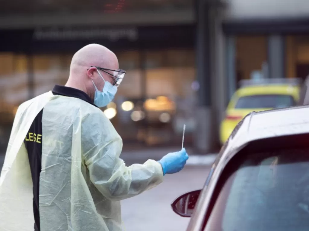 Seorang tenaga kesehatan, Germra Schneider, memeriksa seorang warga di dalam mobil di luar unit gawat darurat di Sandvika, Norwegia, Senin (2/3/2020). (ANTARA/via REUTERS)