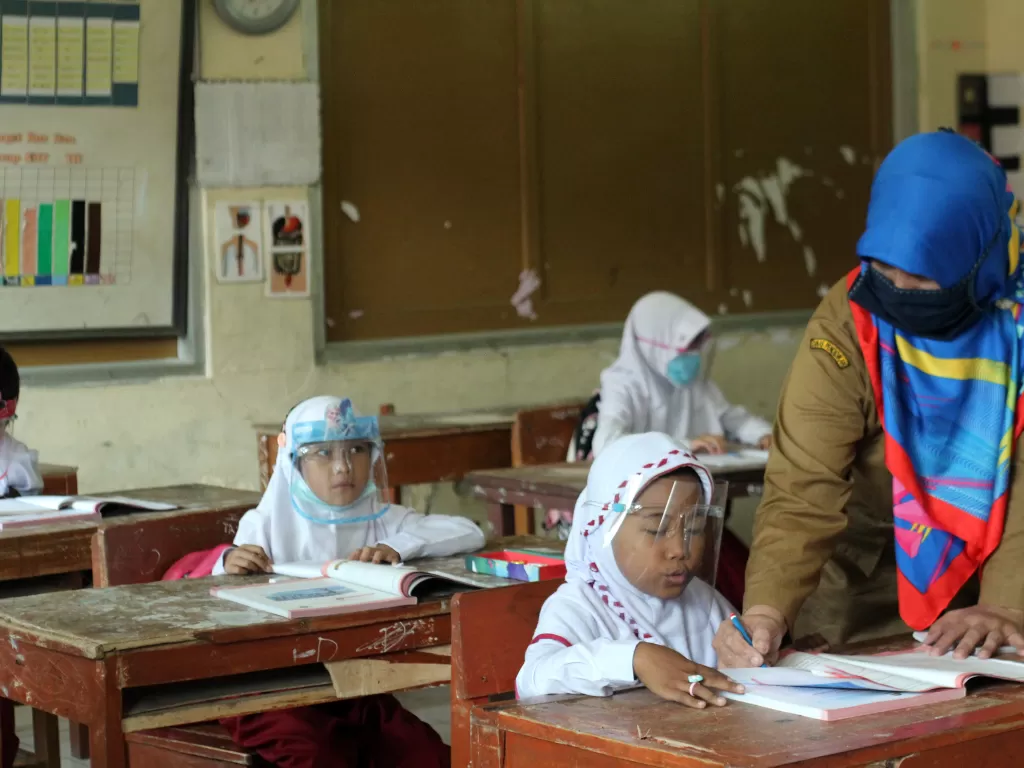 Guru menggunakan masker saat uji coba pembelajaran tatap muka (ANTARA FOTO/Arif Firmansyah)