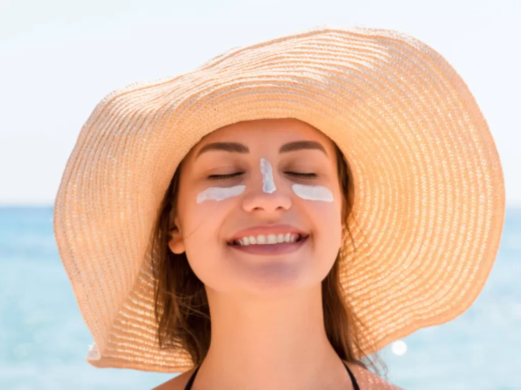 Ilustrasi wanita memakai sunblock di wajah. (Freepik)