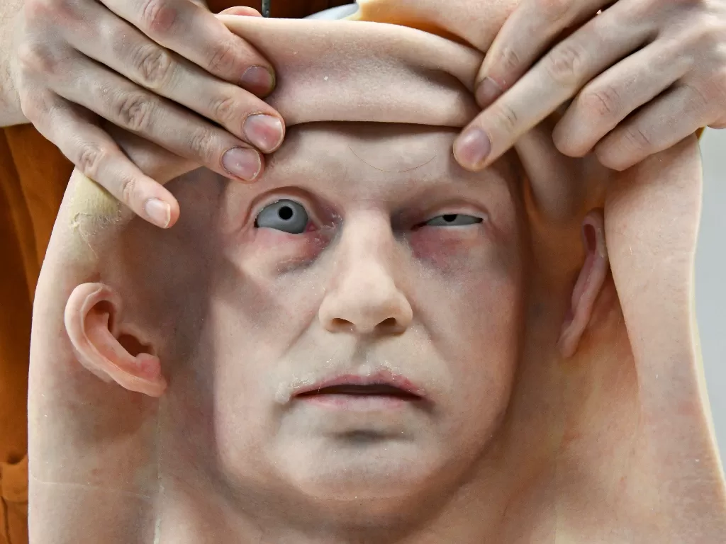 Seorang karyawan menempelkan kulit ke kepala robot humanoid (REUTERS/YURI MALTSEV)