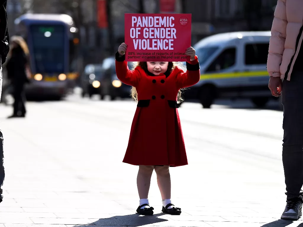 Ariana Lamcellari, 4, memegang papan saat protes menentang kekerasan (REUTERS/Clodagh Kilcoyne)