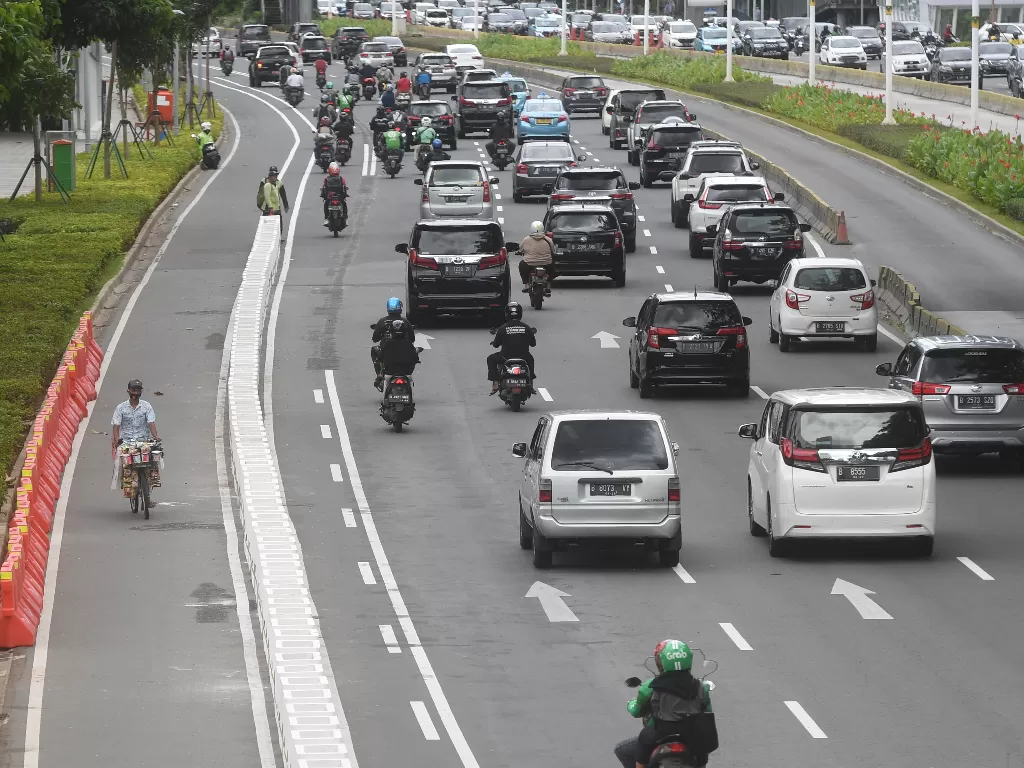 Pesepeda melintasi jalur khusus sepeda yang telah diberikan pembatas jalur permanen di Jalan Jenderal Sudirman, Jakarta, Rabu (24/2/2021).  (photo/ANTARA FOTO/Akbar Nugroho Gumay)