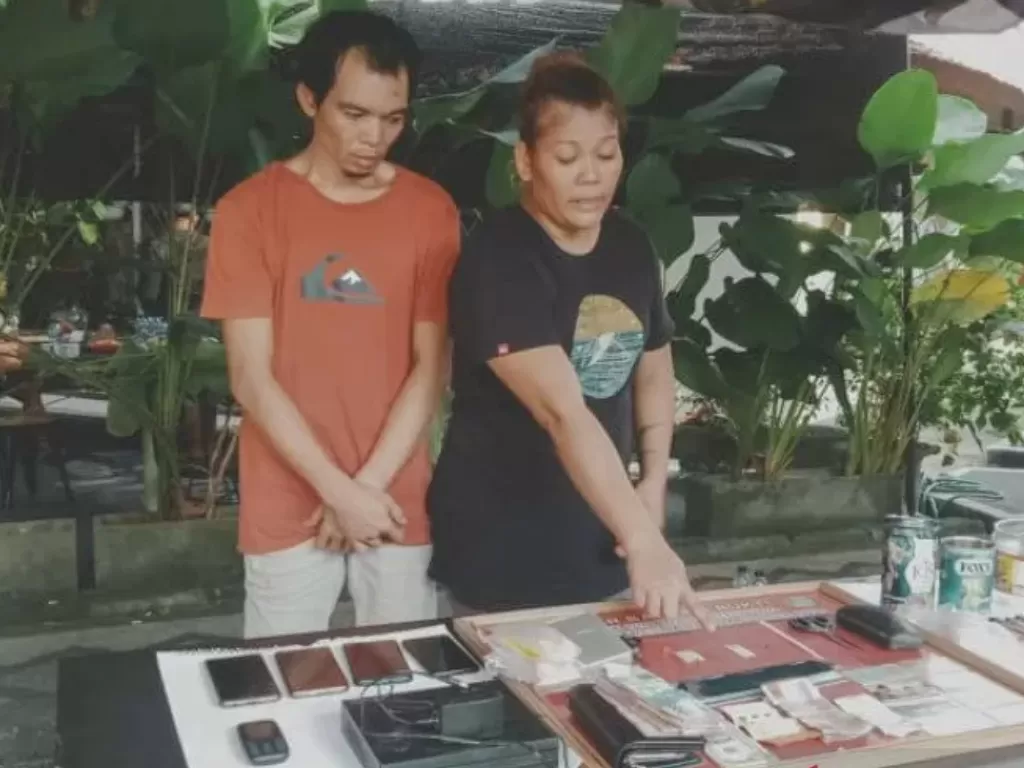Tersangka kasus narkoba, pasangan suami istri JU (kiri) dan DI menunjukkan barang bukti narkoba (Antara)