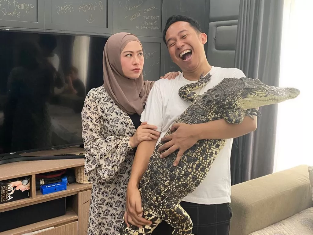 Denny Cagur gendong buaya ditatap sang istri. (Instagram)