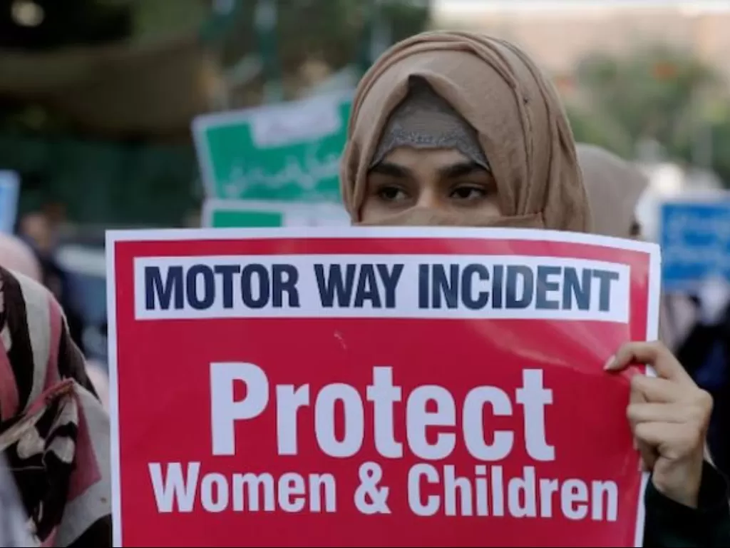 Seorang wanita membawa tanda menentang pemerkosaan berkelompok yang terjadi di sepanjang jalan raya (Reuters)