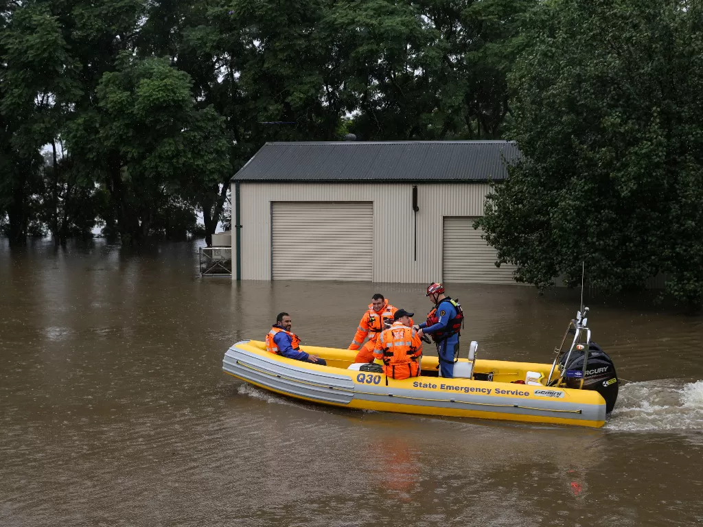  Personel Layanan Darurat Negara Bagian melintasi air banjir yang meluas dan cuaca buruk, di Sydney, Australia, Maret 22, 2021. (photo/REUTERS/Loren Elliott)