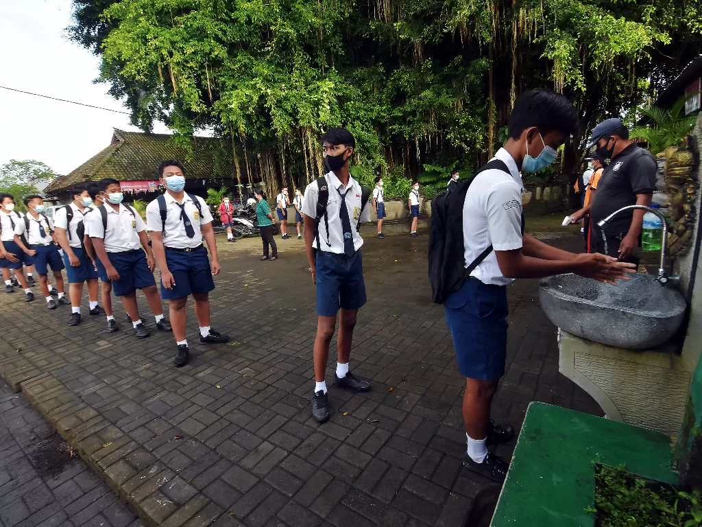 Siswa mencuci tangan saat akan memasuki area sekolah (ANTARA FOTO/Nyoman Hendra Wibowo)
