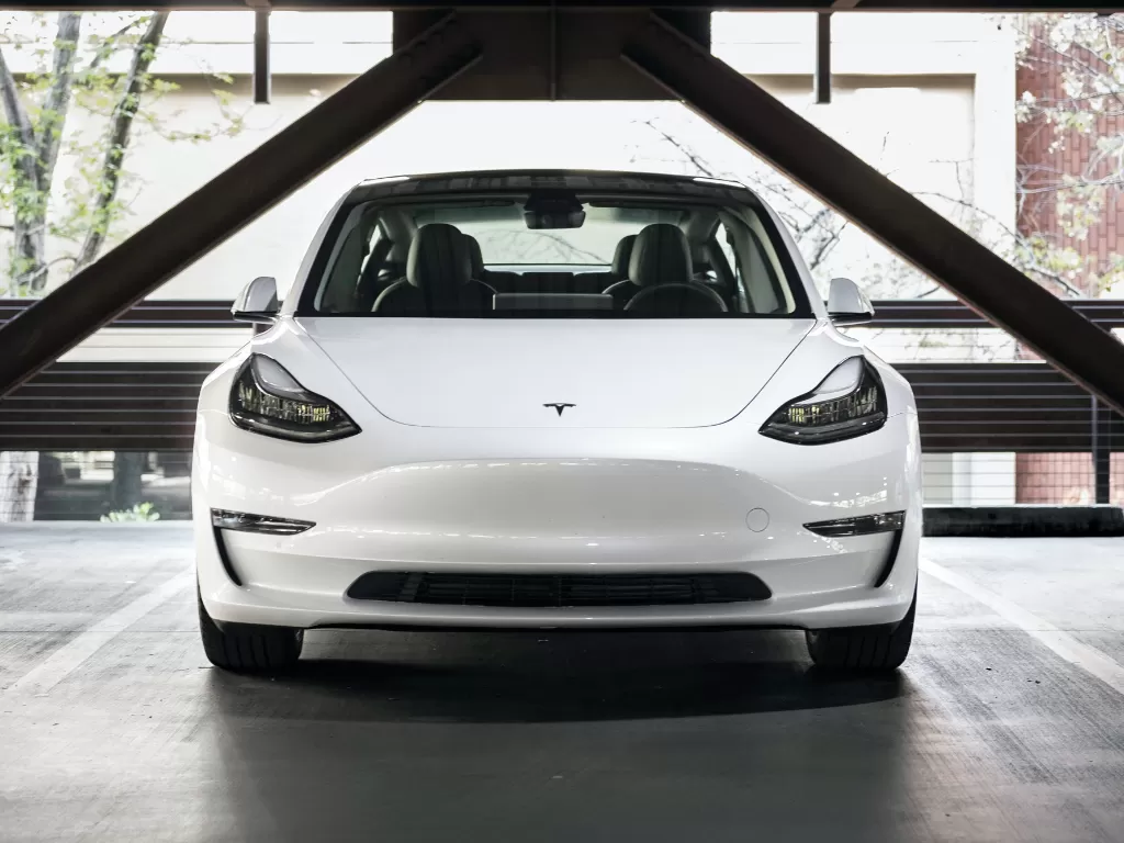 Tampilan depan dari mobil listrik Tesla berwarna putih (photo/Unsplash/Charlie Deets)