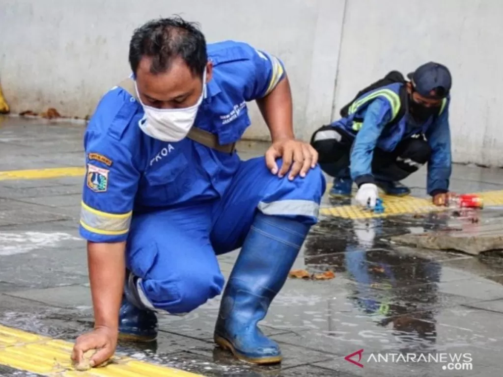 Petugas membersihkan trotoar di sepanjang Jalan Sudirman, Jakarta Selatan, Sabtu (27/3/2021). (photo/ANTARA/HO-Sudin Kominfotik Jakarta Selatan)