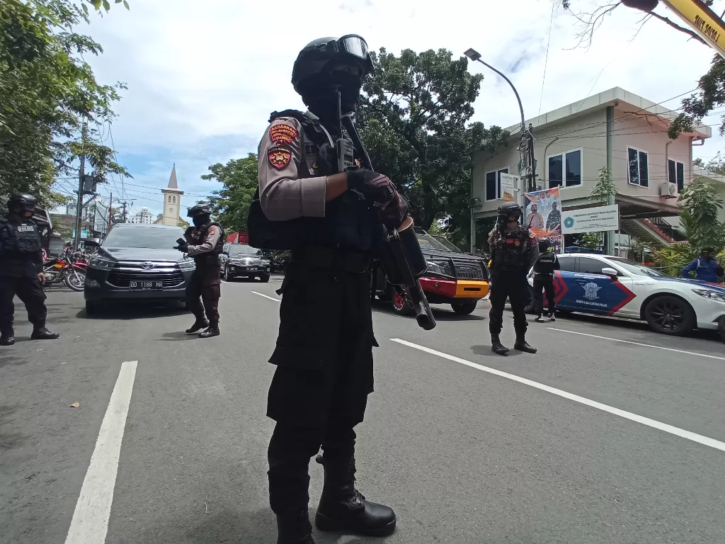 Petugas kepolisian berjaga di lokasi dugaan bom bunuh diri di depan Gereja Katedral Makassar, Sulawesi Selatan, Minggu (28/3/2021). (ANTARA/Abrian Abhe)