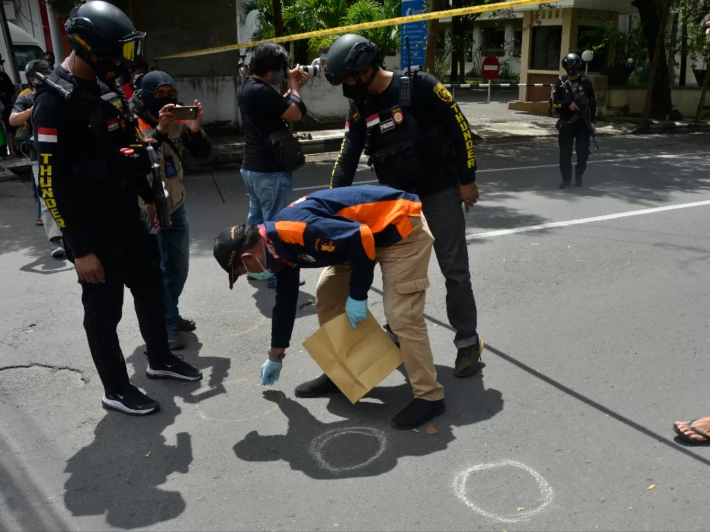 Petugas kepolisian melakukan pemeriksaan di sekitar sisa-sisa ledakan dugaan bom bunuh diri di depan Gereja Katolik Katedral, Makassar, Sulawesi Selatan. (Foto: ANTARA/Abriawan Abhe)