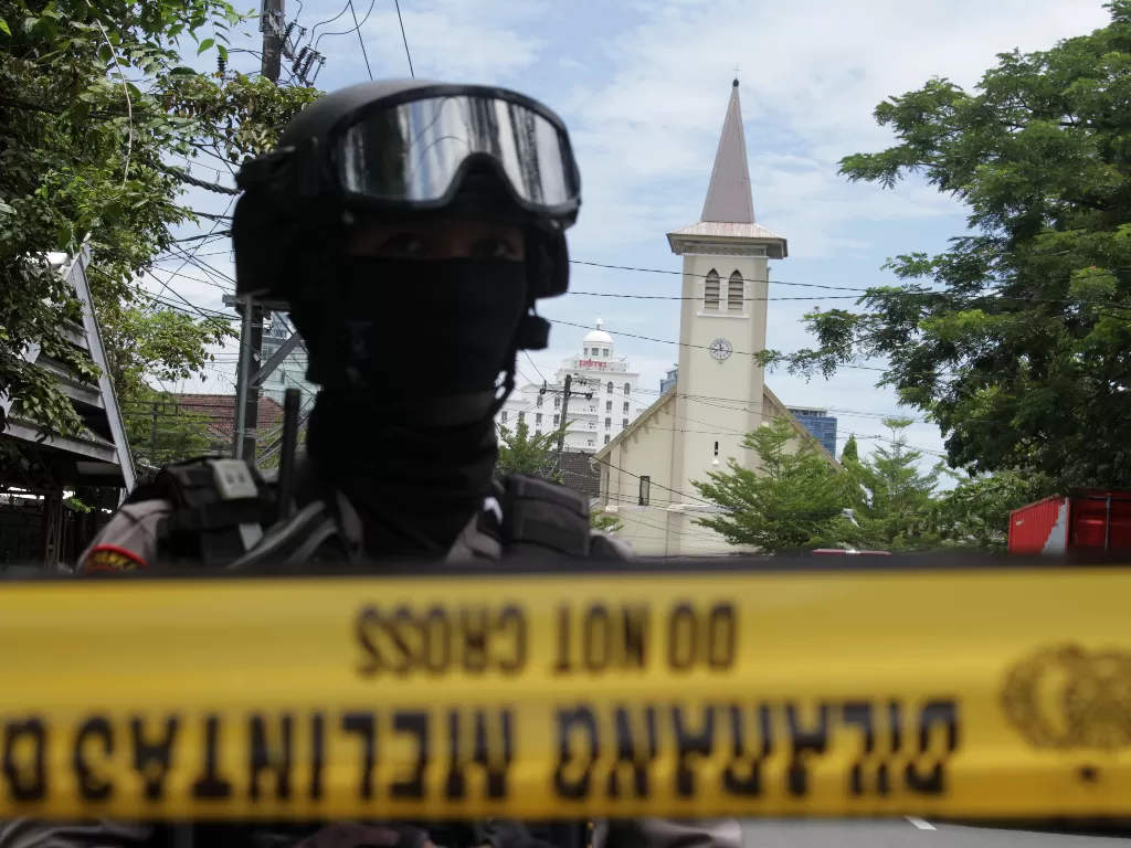 Anggota polisi berjada di ruas jalan menuju Gereja Katedral Makassar yang menjadi lokasi ledakan bom. (Foto: ANTARA/Arnas Padda)