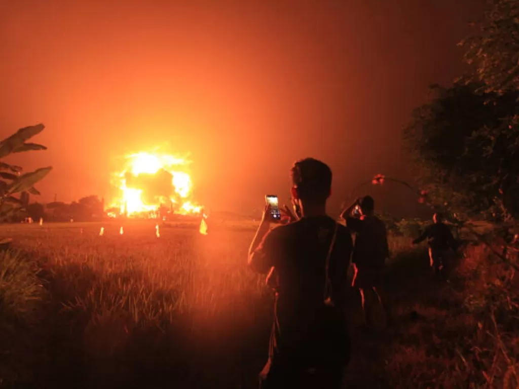 Warga mengabadikan kejadian ledakan di kilang minyak Indramayu. (ANTARA FOTO/Dedhez Anggara).