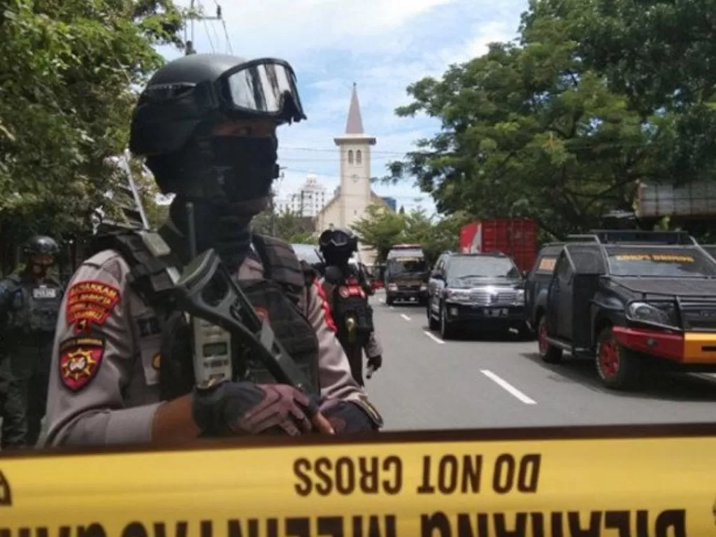  Petugas kepolisian berjaga di lokasi dugaan bom bunuh diri di depan Gereja Katedral Makassar, Sulawesi Selatan, Minggu (28-3-2021). (ANTARA FOTO/Arnas Padda)
