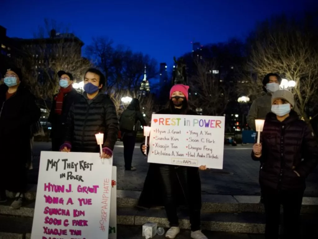 Warga membawa poster dan lilin saat mereka menghadiri renungan untuk berduka atas korban kejahatan rasial anti-Asia di New York City, New York, Amerika Serikat, Jumat (19/3/2021). (photo/REUTERS/EDUARDO MUNOZ)