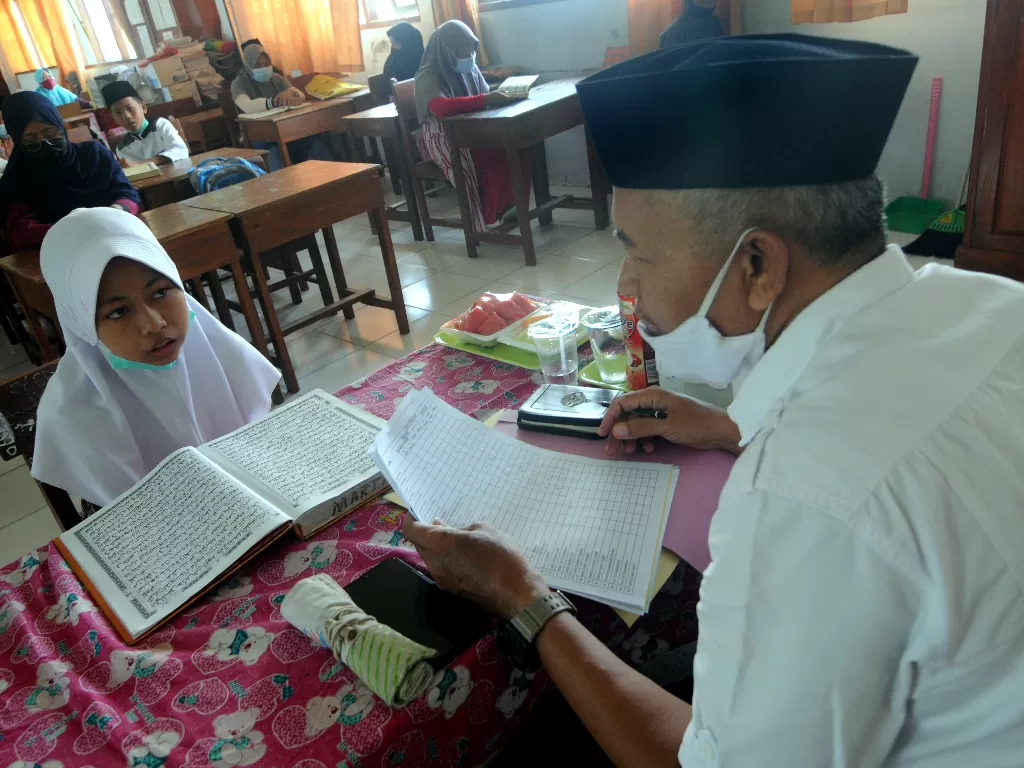 Penguji menyimak bacaan dan hafalan surat pendek Alquran siswa (ANTARA FOTO/Saiful Bahri)