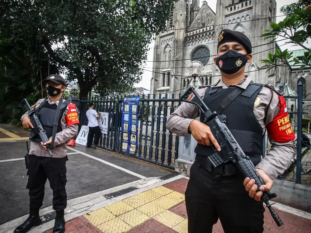 Anggota kepolisian berjaga di depan Gereja Katedral, Jakarta, Kamis (1/4/2021). (photo/ANTARA FOTO/Rivan Awal Lingga)