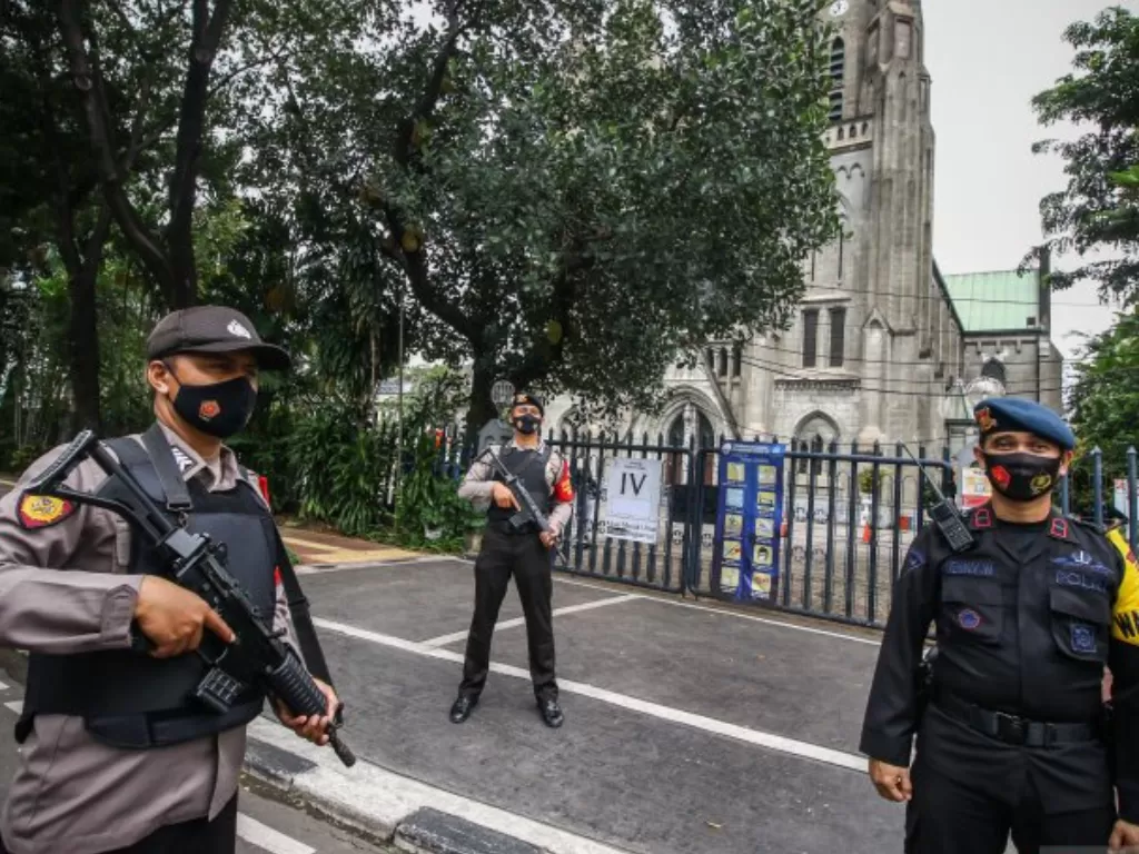 Personel kepolisian berjaga di depan Gereja Katedral, Jakarta, Kamis (1/4/2021). (ANTARA FOTO/Rivan Awal Lingga)