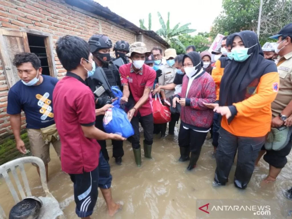   Menteri Sosial Tri Rismaharini menbagikan bantuan logistik langsung pada para korban bencana banjir di Kabupaten Bima, Nusa Tenggara Barat, Senin (5/4/2021). (photo/ANTARA/HO-Kemensos RI)