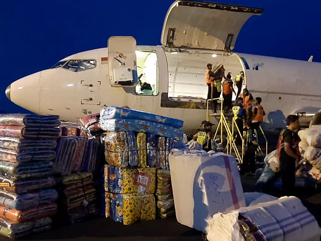 Pekerja membongkar muat bantuan logistik dari pesawat terbang di Bandara Frans Seda, Maumere, NTT, Senin (5/4/2021).  (photo/ANTARA FOTO/Dedy)