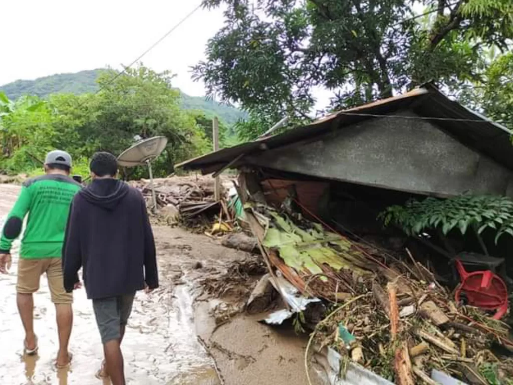 Warga melintas di dekat rumah yang rusak akibat banjir bandang di Adonara Timur, Flores Timur, NTT. (Foto: ANTARA/Pion Ratuloli)