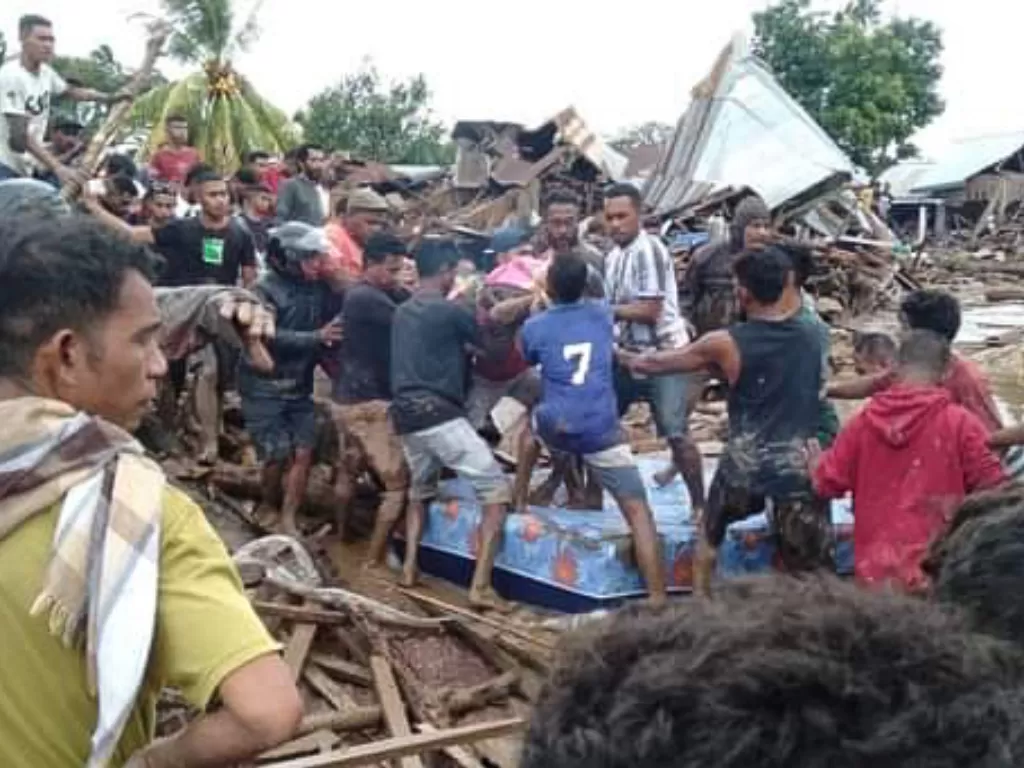Warga mengevakuasi korban akibat banjir bandang di Adonara Timur, Flores Timur, NTT, Senin (5/4/2021). (photo/ANTARA FOTO/Pion Ratuloli)