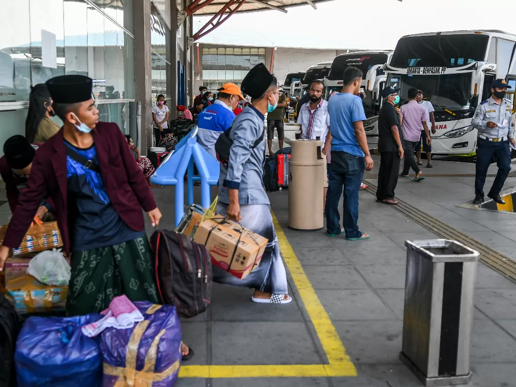 Calon penumpang bersiap menaiki bus di Terminal Terpadu Pulo Gebang, Jakarta, Jumat (26/3/2021). (photo/ANTARA FOTO/Galih Pradipta)