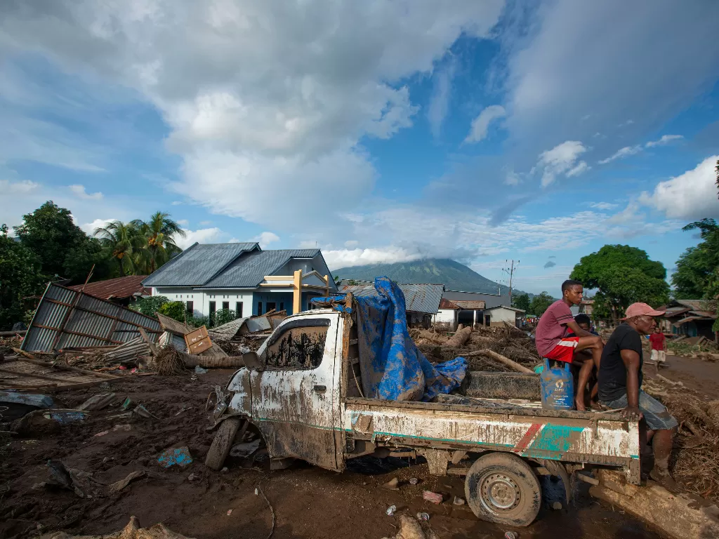  Sejumlah warga duduk di atas mobil yang rusak akibat banjir bandang di Adonara Timur, Kabupaten Flores Timur, Nusa Tenggara Timur (NTT), Selasa (6/4/2021). (photo/ANTARA FOTO/Aditya Pradana Putra)