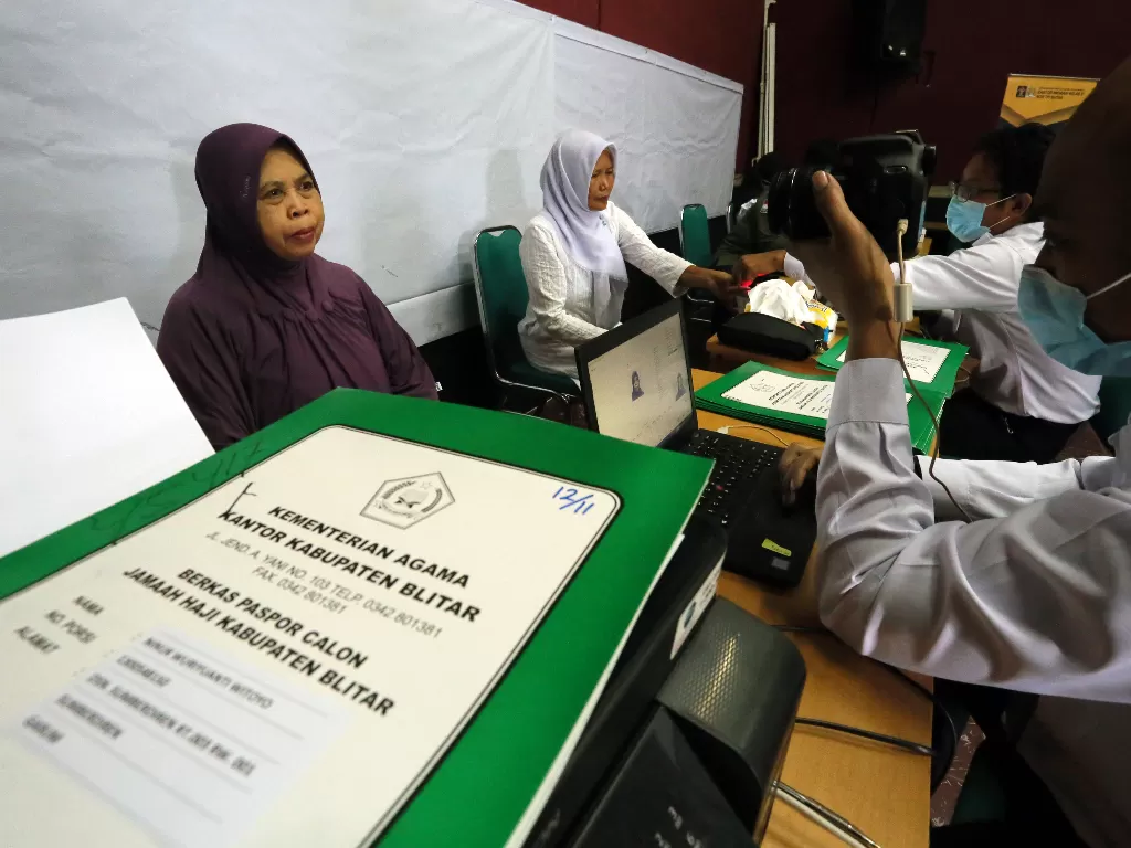 Petugas Kantor Imigrasi Kelas II Non TPI Blitar merekam data calon haji yang dijadwalkan berangkan ke Tanah Suci tahun 2021 di Kantor Kementerian Agama Blitar, Jawa Timur, Rabu (7/4/2021). (photo/ANTARA FOTO/Irfan Anshori)