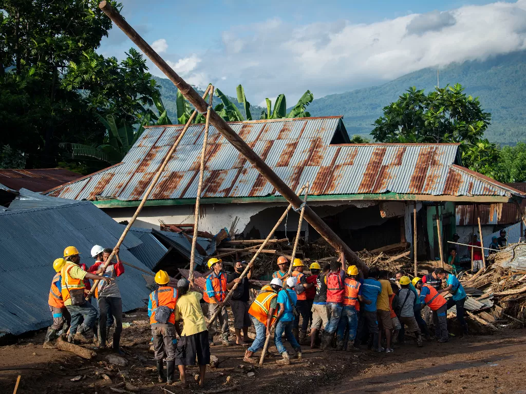  Sejumlah pekerja bergotong royong mendirikan tiang listrik di lokasi terdampak banjir bandang di Adonara Timur, Kabupaten Flores Timur, Nusa Tenggara Timur (NTT), Selasa (6/4/2021). (photo/ANTARA FOTO/Aditya Pradana Putra)
