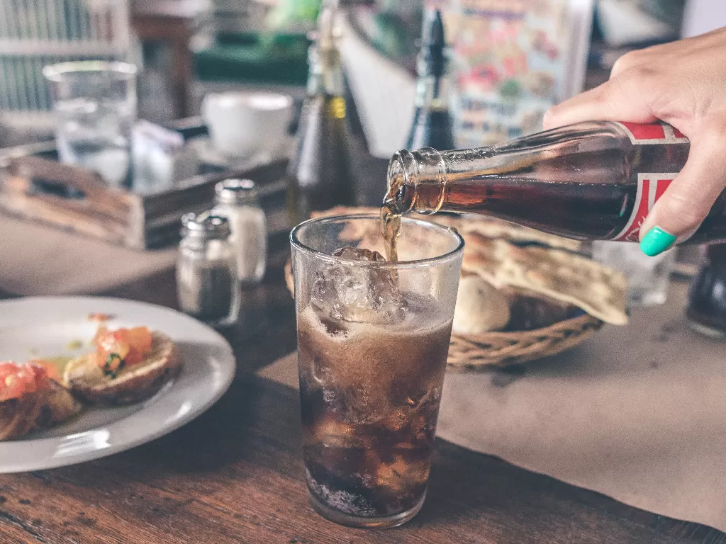 Ilustrasi makan mie dan minum soda (Photo by Artem Beliaikin from Pexels)