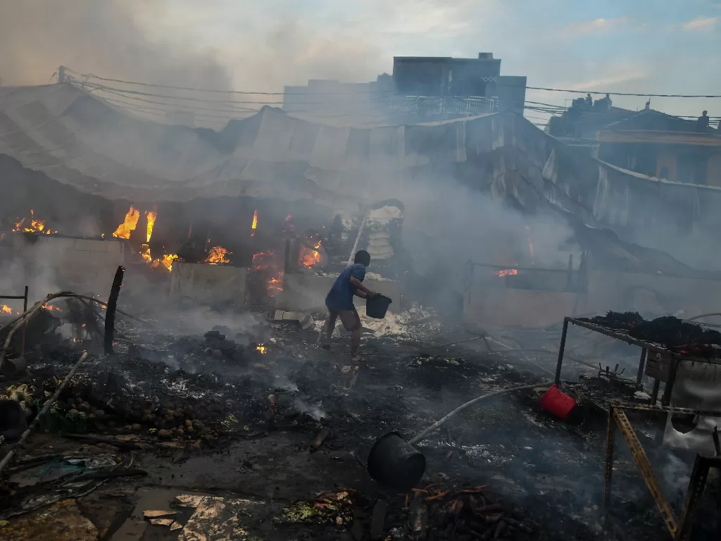  Warga memadamkan api yang membakar Pasar Lontar atau Pasar Kambing di Jalan Sabeni, Tanah Abang, Jakarta, Kamis (8/4/2021).  (photo/ANTARA FOTO/Galih Pradipta)
