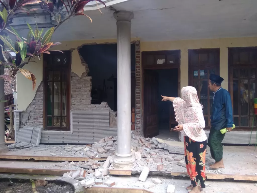 Warga menyaksikan rumah yang rusak akibat gempa di Kecamatan Turen, Kabupaten Malang, Jawa Timur, Sabtu (10/4/2021).  (photo/ANTARA FOTO/STR/SA)