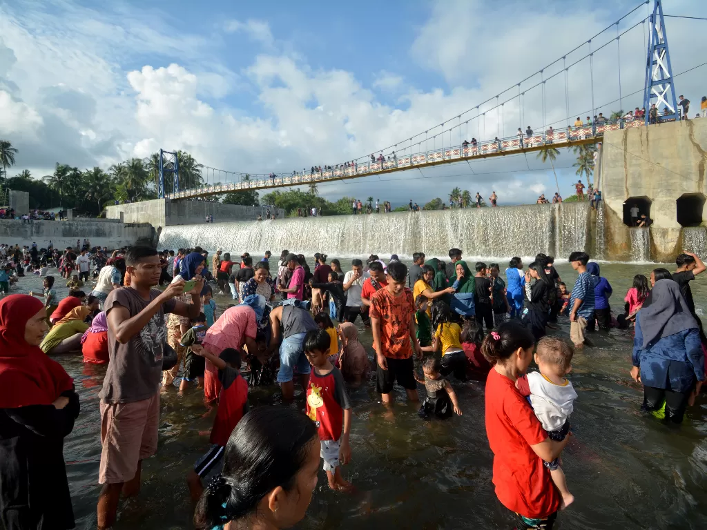 Sejumlah warga mandi-mandi di kawasan Cek Dam Koto Tuo, Padang, Sumatera Barat, Senin (12/4/2021).  (photo/ANTARA FOTO/Iggoy el Fitra)