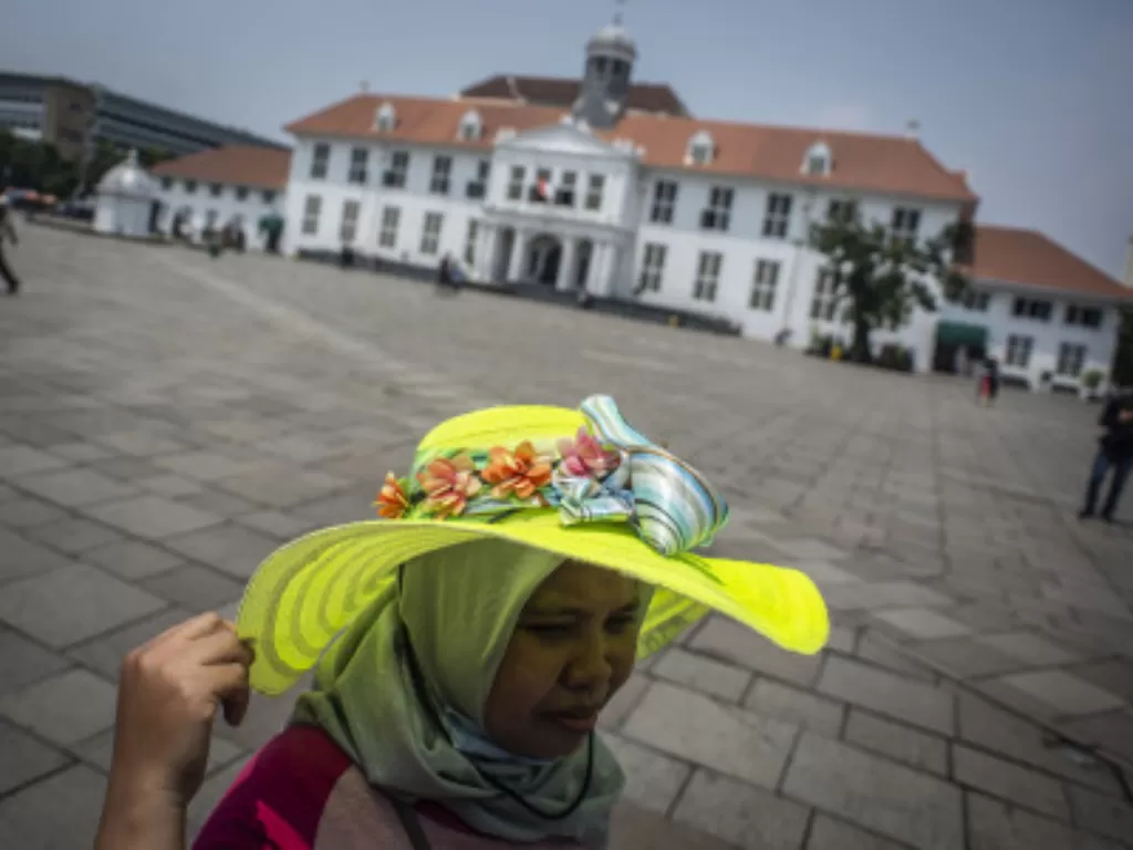 Wisatawan mengunjungi Taman Fatahillah di kompleks Kota Tua, Jakarta, Minggu (11/4/2021). (ANTARA FOTO/Aprillio Akbar)