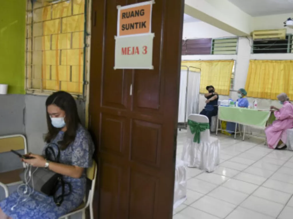Tenaga kesehatan menyuntikkan vaksin COVID-19 pada tenaga pendidik di SMP 216, Jakarta, Selasa (6/4/2021).  (ANTARA FOTO/Galih Pradipta/).