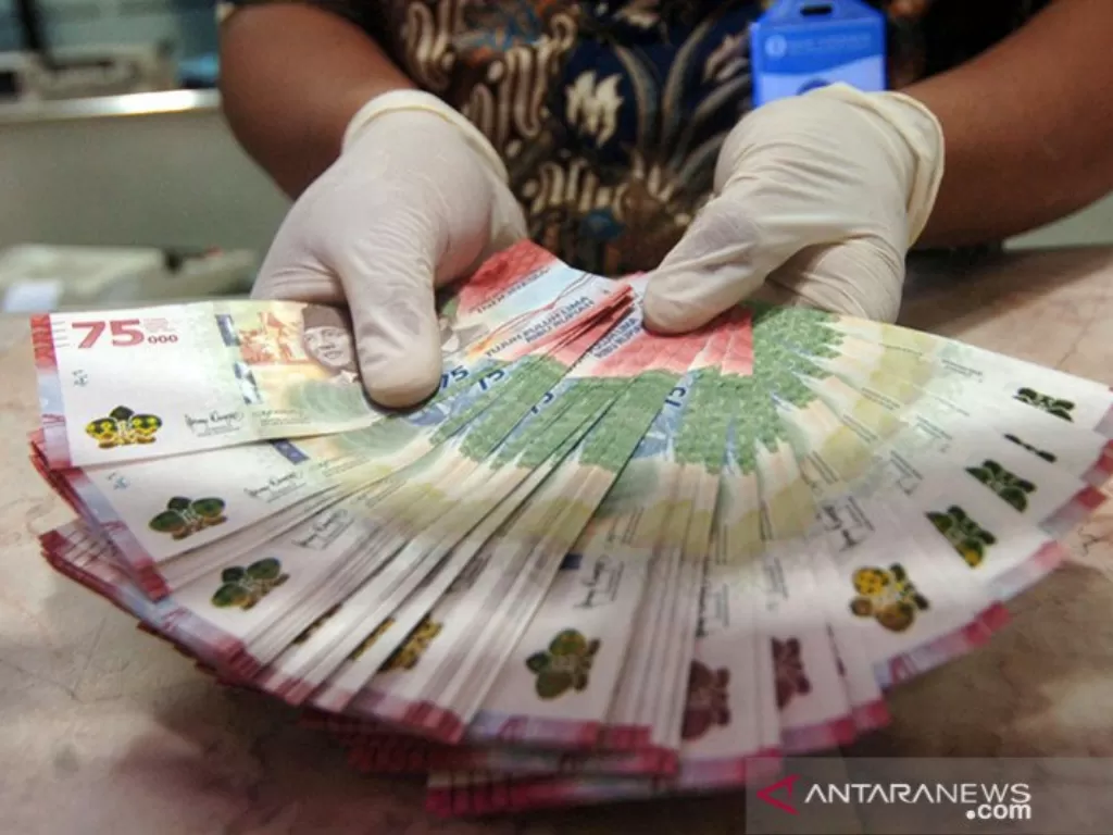 Petugas menunjukkan uang baru pecahan Rp75.000. (ANTARA FOTO/Oky Lukmansya)