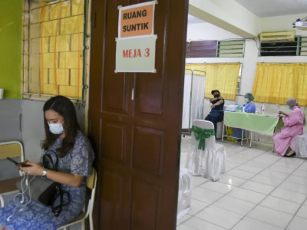 Tenaga kesehatan menyuntikkan vaksin COVID-19 pada tenaga pendidik di SMP 216, Jakarta, Selasa (6/4/2021). (ANTARA FOTO/Galih Pradipta/).