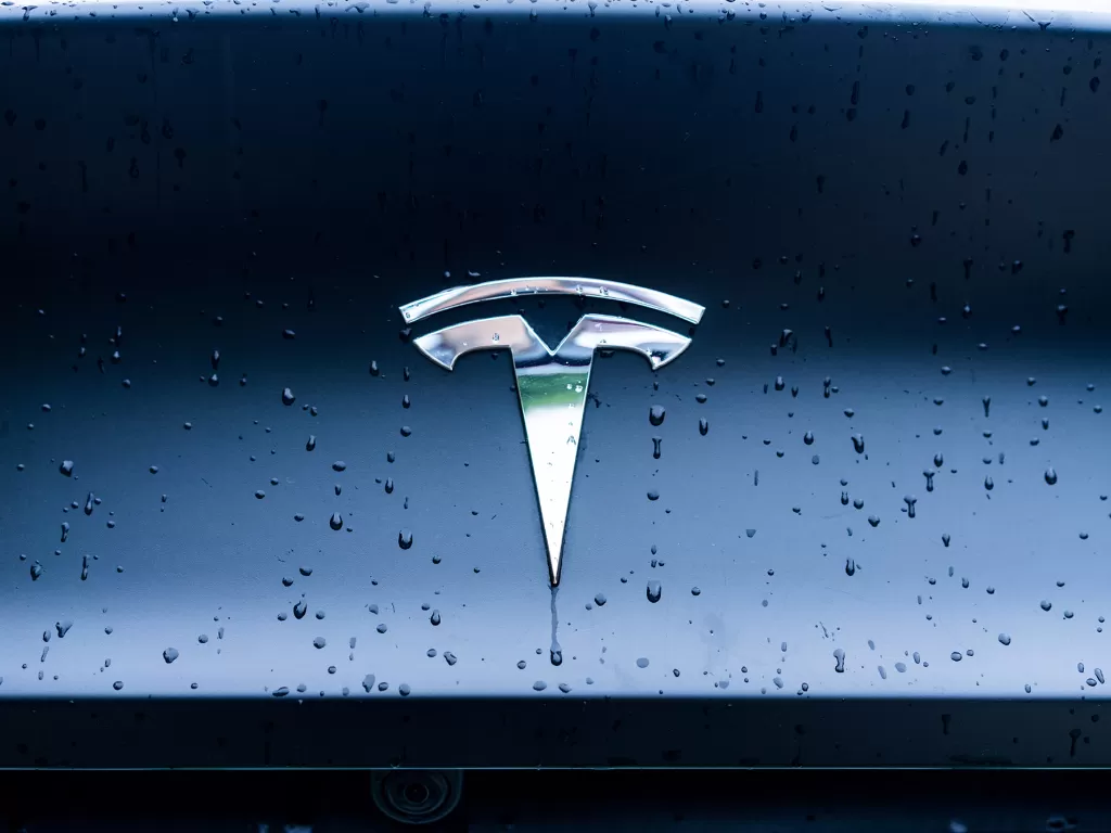 Logo perusahaan otomotif Tesla di salah satu mobil buatannya (phoro/Unsplash/Li Xiang)