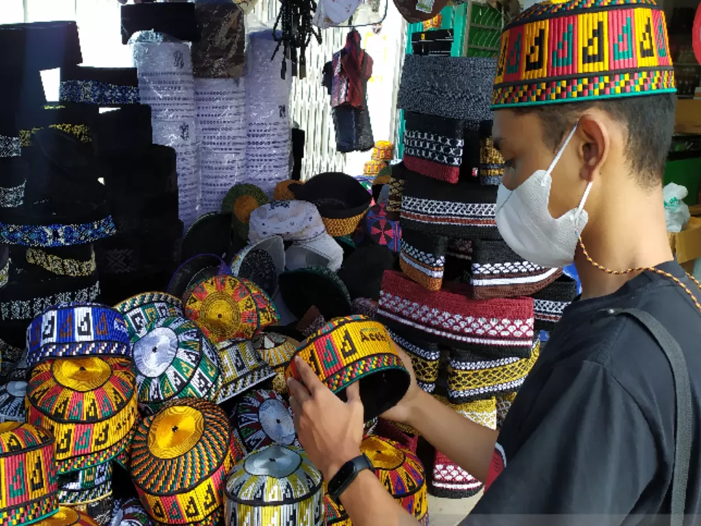  Salah seorang warga sedang mencoba-coba untuk membeli peci kupiah meukutop, di Banda Aceh, Kamis (15/4/2021). (ANTARA/Rahmat Fajri) 