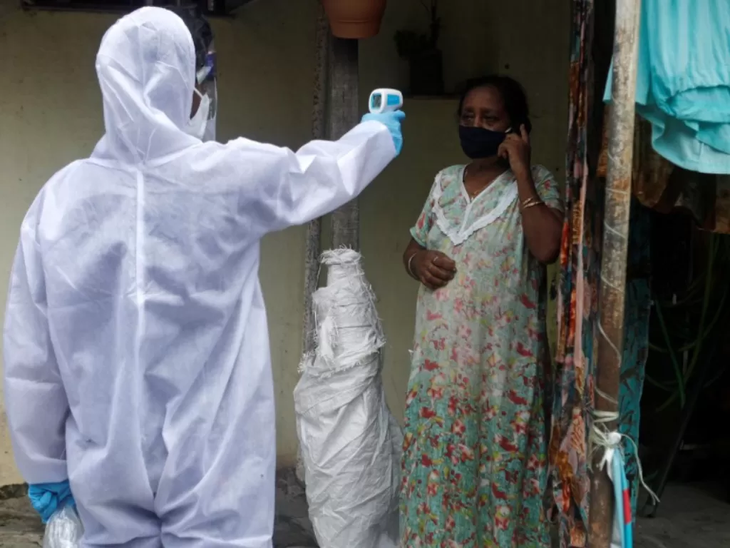 Petugas kesehatan memeriksa suhu tubuh warga di Mumbai, India. (REUTERS/Francis Mascarenhas)
