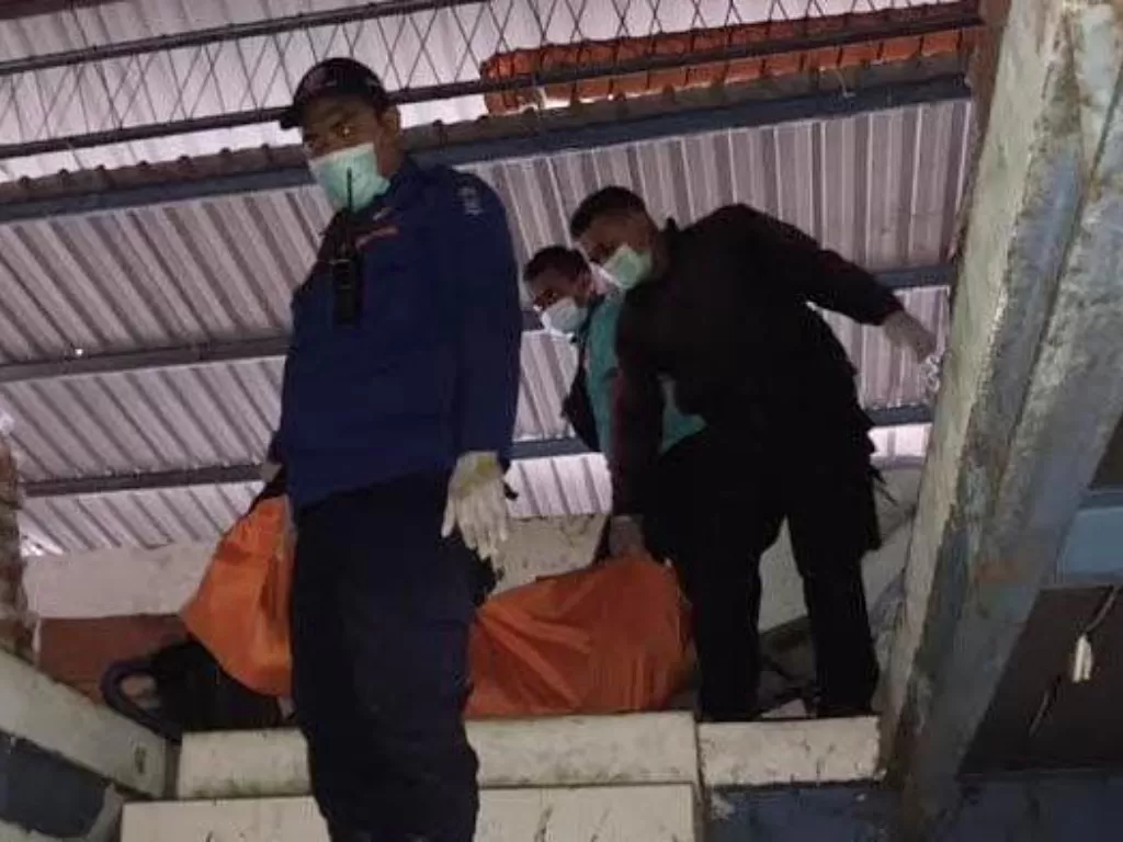 Petugas evakuasi pekerja pria yang tewas terjepit pintu lift di gudang (Instagram/surabaya.terkini)