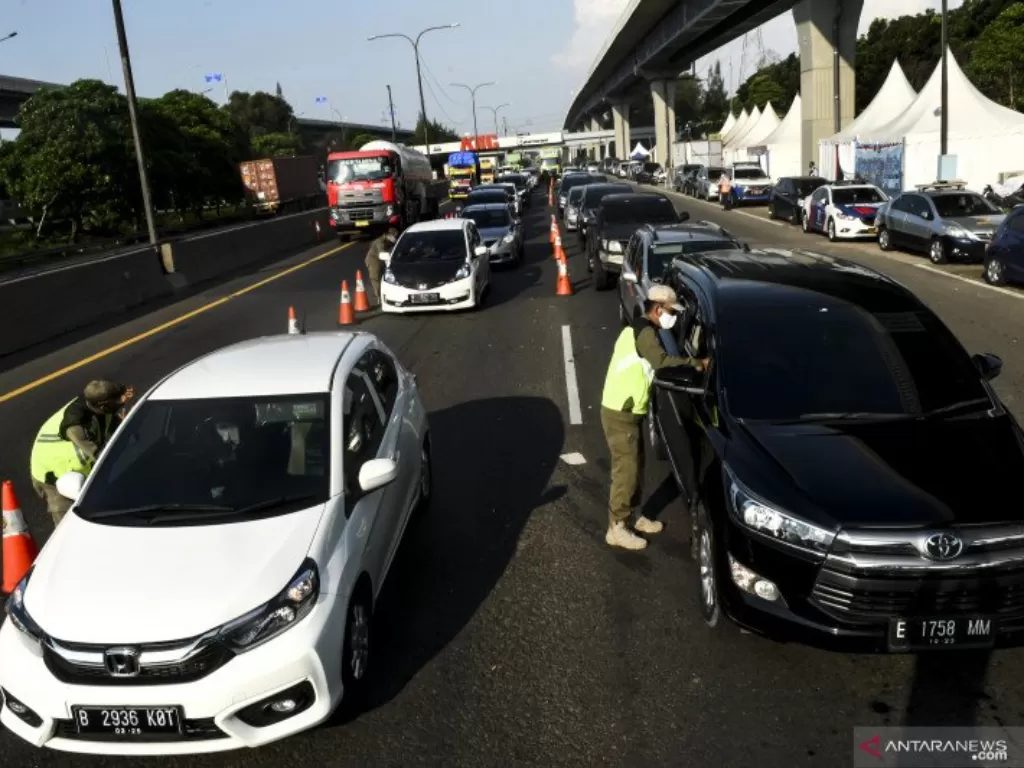 Petugas gabungan memeriksa kendaraan yang akan masuk ke wilayah DKI Jakarta di KM 47 Tol Cikampek-Jakarta, Jawa Barat, Sabtu (30/5/2020).  (ANTARA FOTO/Muhammad Adimaja/wsj.).