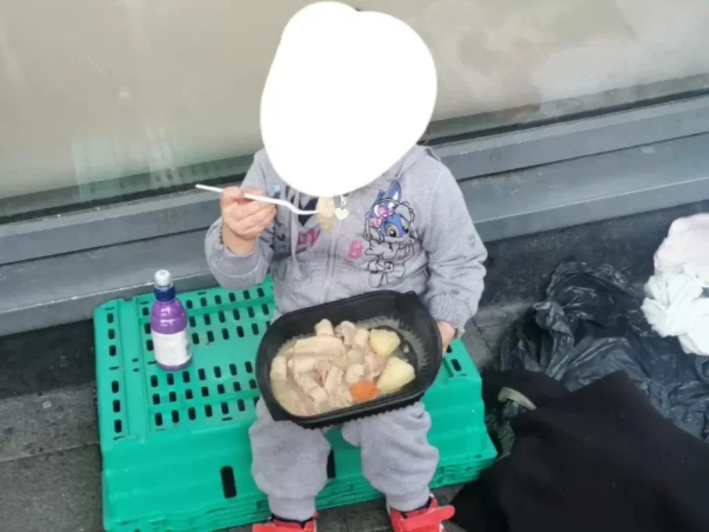 Bocah 4 tahun ini terlihat makan di belakang dapur umum karena tak punya rumah (Facebook/Ballymun Soup Run)