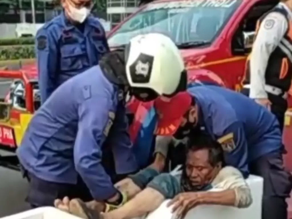 Pria diduga gangguan jiwa terjepit di beton Jalan Sudirman. (Instagram/damkar_jakpus)