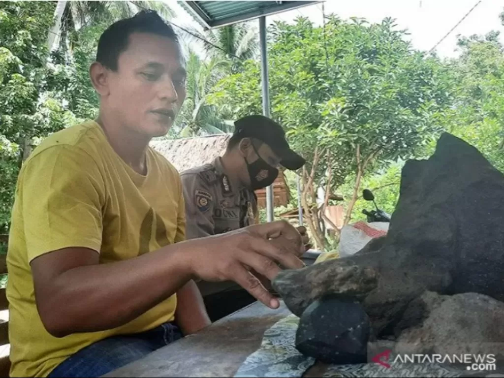 Warga Kecamatan VII Koto, Kabupaten Padang Pariaman, Sumatera Barat Robi Tamar (40) memegang batu yang ditemukannya dan ia menduga kuat batuan tersebut merupakan meteor. ANTARA/Aadiaat M. S./am.