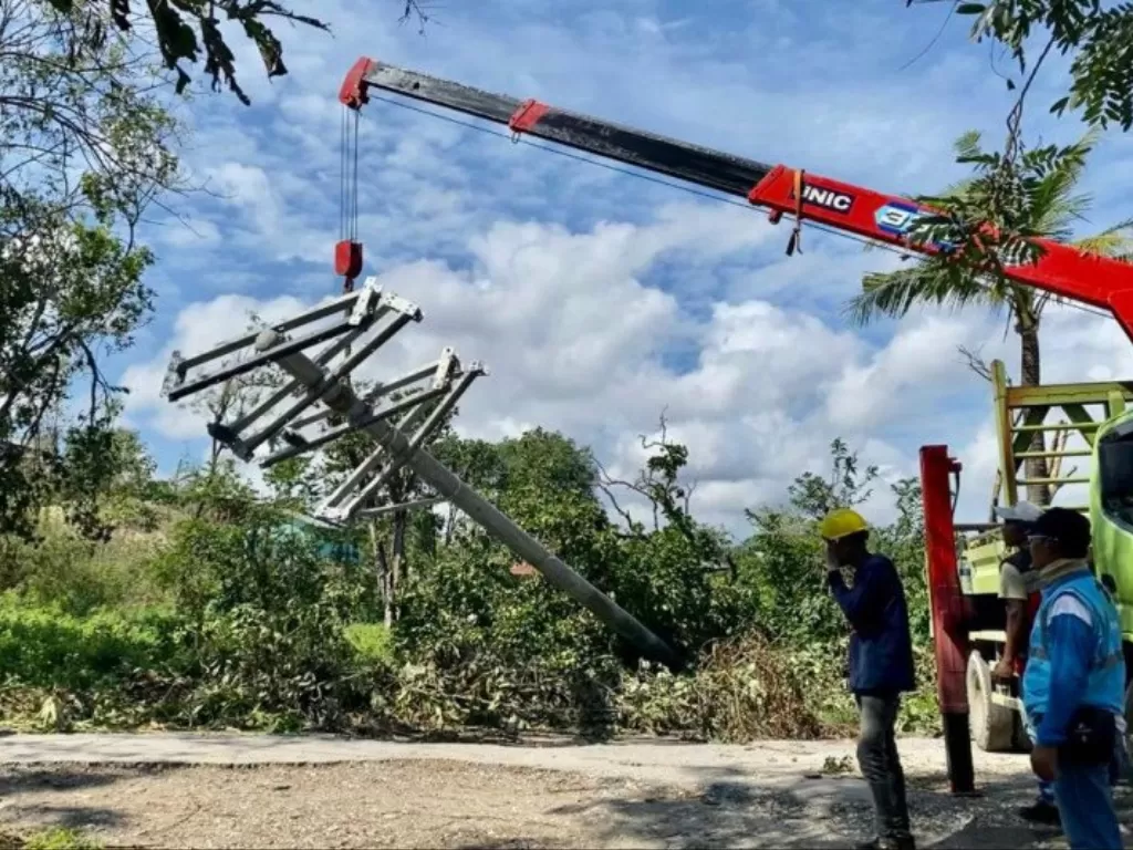  Sejumlah petugas menggunakan peralatan untuk meperbaiki tiang listrik yang roboh akibat badai siklon tropis Seroja di Pulau Sumba, Nusa Tenggara Timur, Senin (19/4/2021). (ANTARA/HO-PLN UP3 Sumba) 