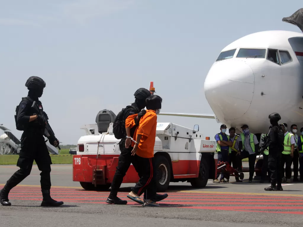 Personel Densus 88 Anti Teror membawa terduga teroris menuju ke pesawat udara di Bandara Internasional Juanda, Sidoarjo, Jawa Timur, Kamis (18/3/2021). (photo/ANTARA FOTO/Umarul Faruq)