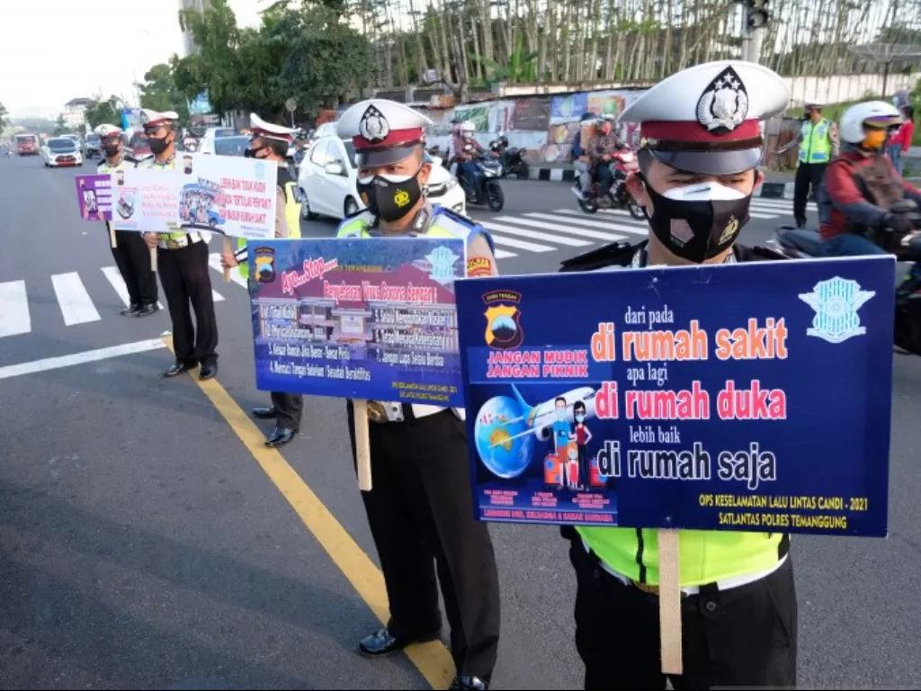 Sejumlah polisi membawa poster saat kampanye larangan mudik di kawasan Terminal Madureso, Temanggung, Jateng, Rabu (21/4/2021). (ANTARA FOTO/Anis Efizudin)