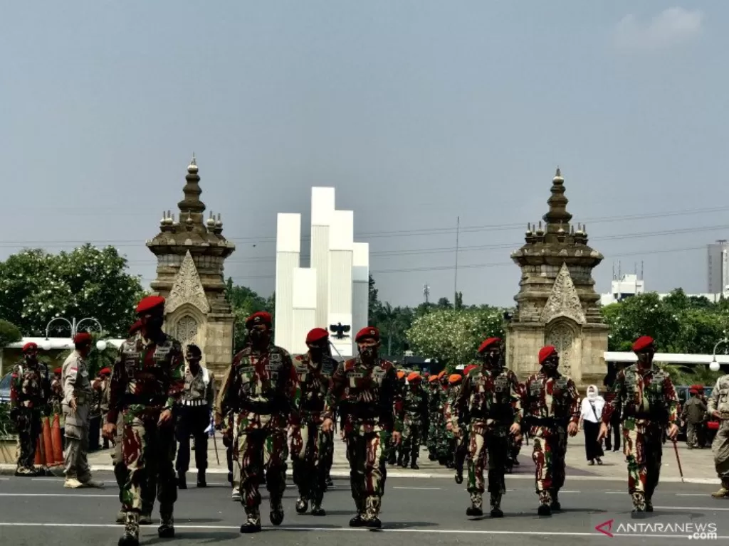 Sejumlah anggota TNI berjalan keluar kompleks Taman Makam Pahlawan (TMP) Kalibata, Jakarta, Selasa (27/4/2021). (ANTARA/Genta Tenri Mawangi)